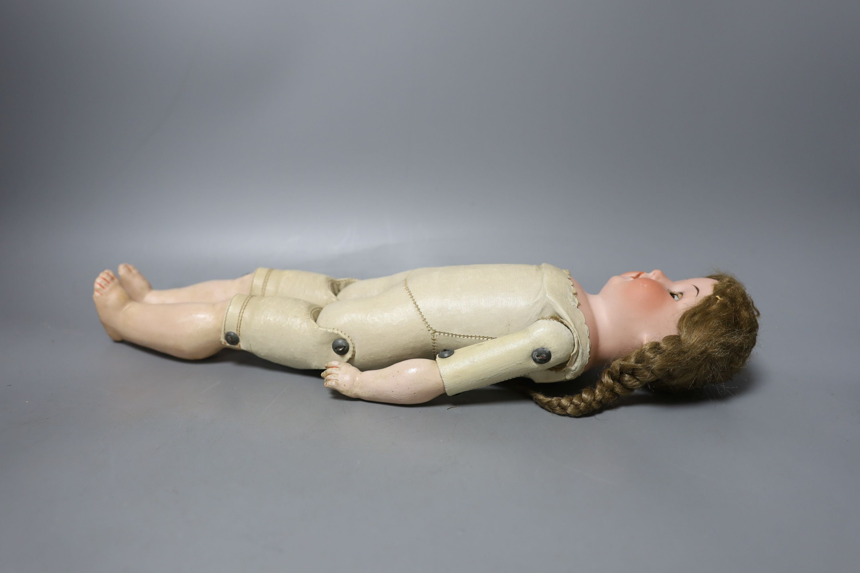 A kid leather bodied jointed limb open mouth Heubach bisque headed doll together with two other bisque headed dolls and a boy doll (damaged)